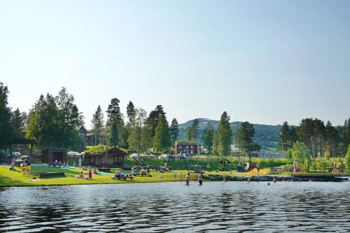 Badeplass med mangge gjester en sommerdag, foto