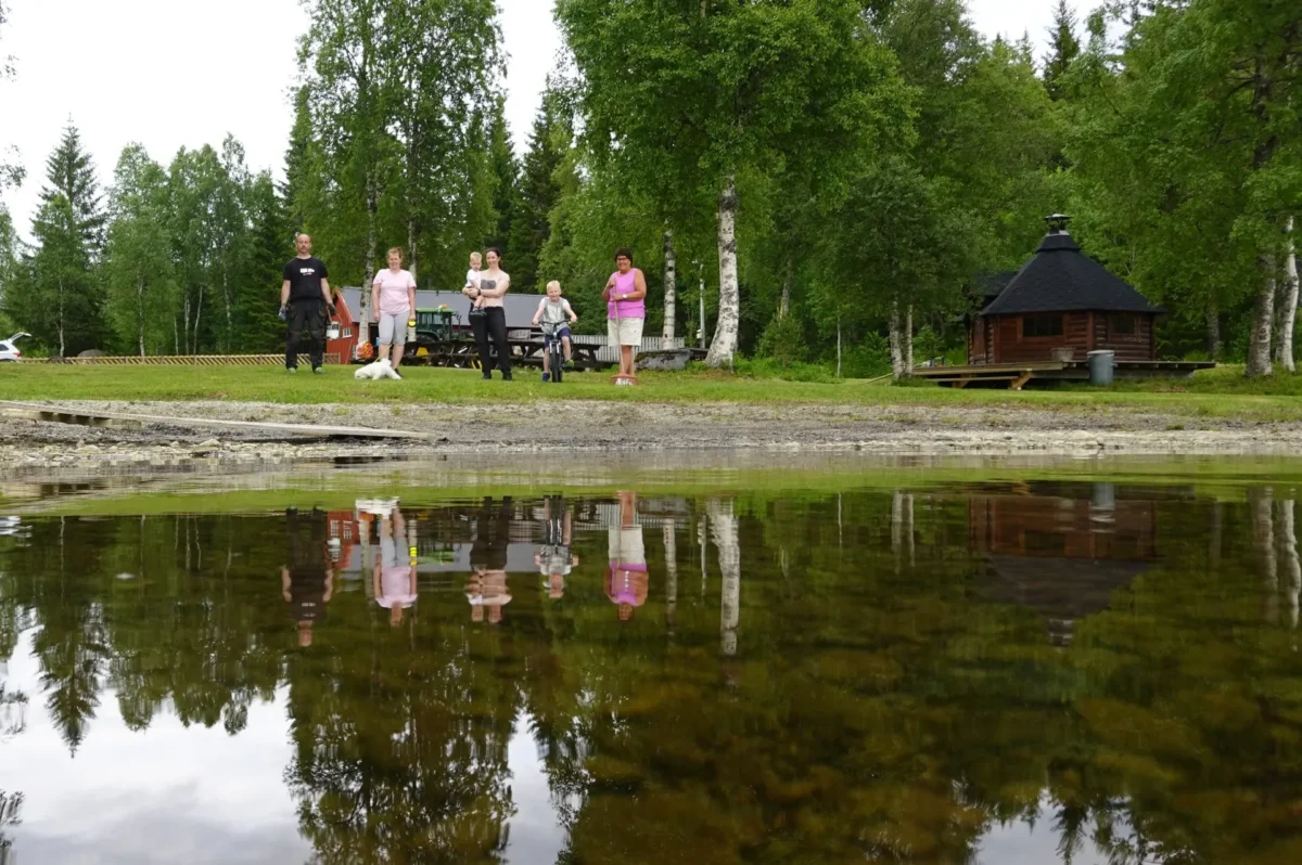 Folk står på stranden, foto