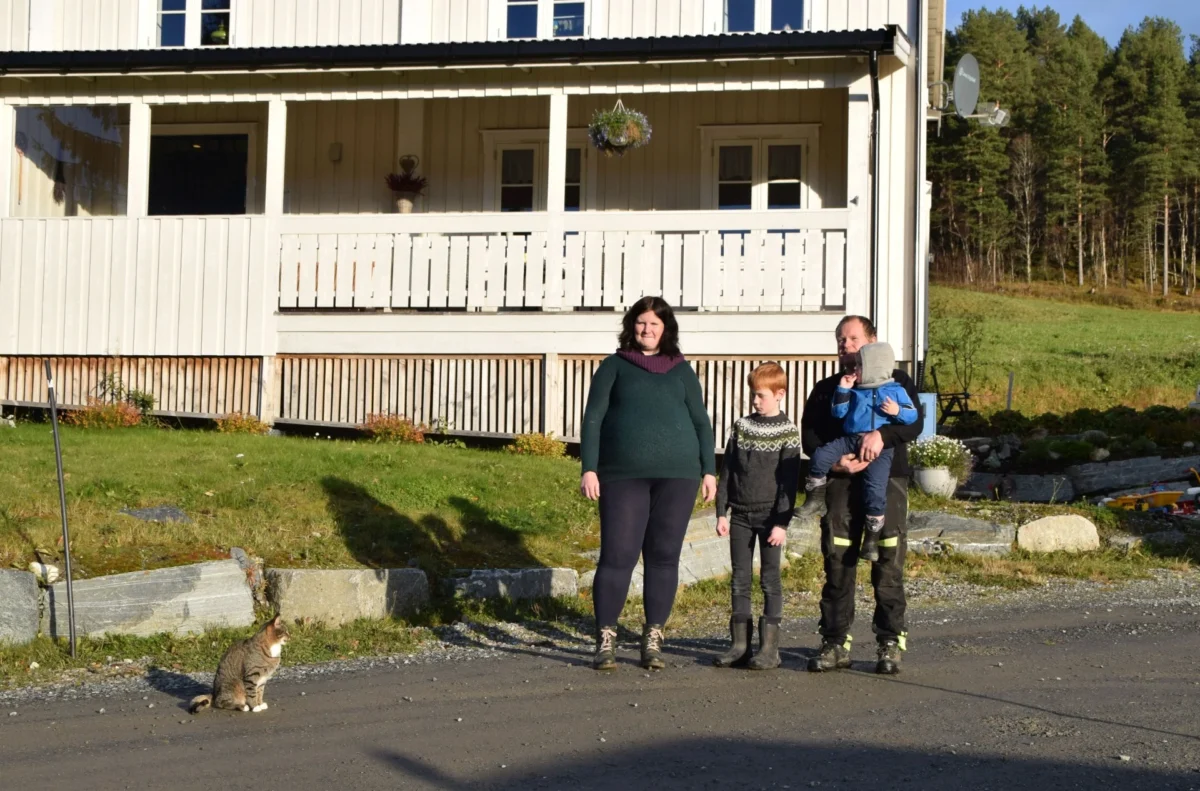 Familie og en katt står foran huset, foto