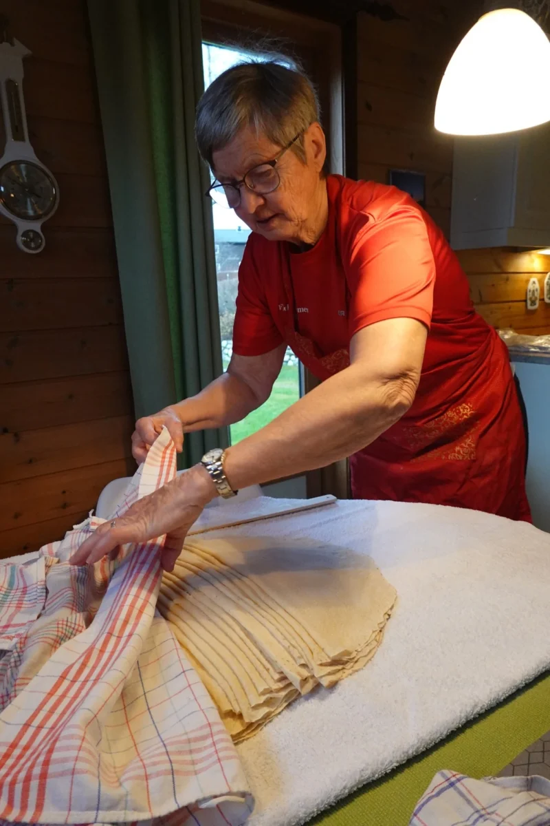 Kvinne dekker over lemser med kjøkkenhåndduk, foto