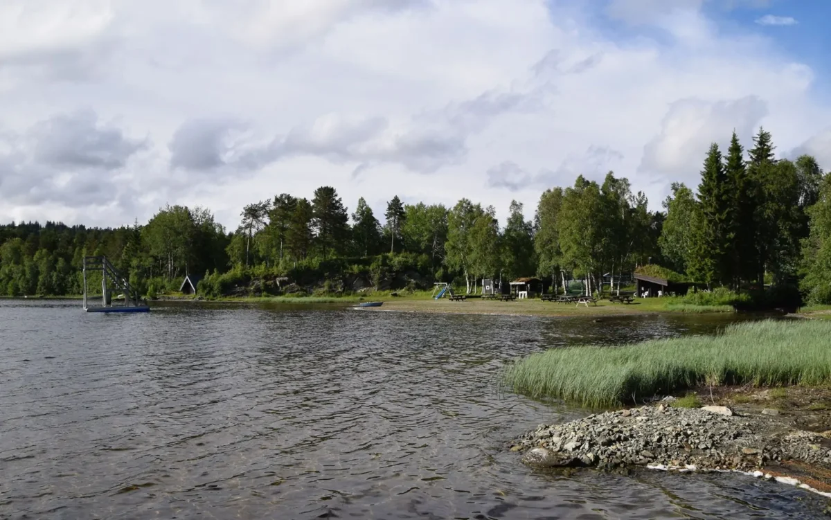 Badevann, innsjø og liten strand med benker, foto