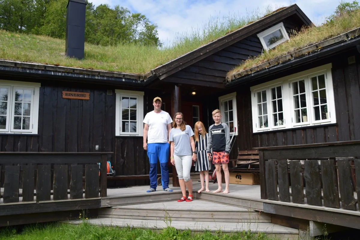 Familie står på trappa til hytta, foto