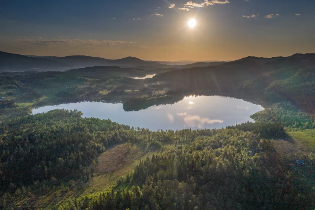 Fjellandskap med vann, i solnedgang, dronefoto