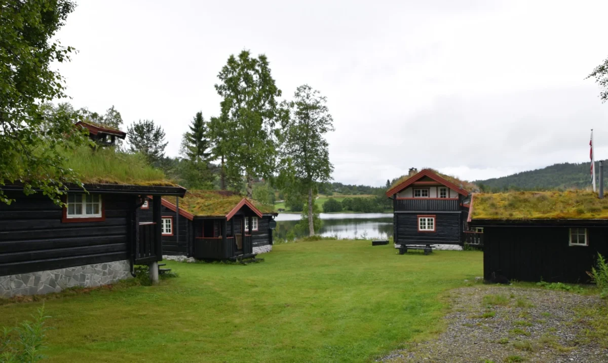 Flere laftede bygninger på et lite hyttetun, foto