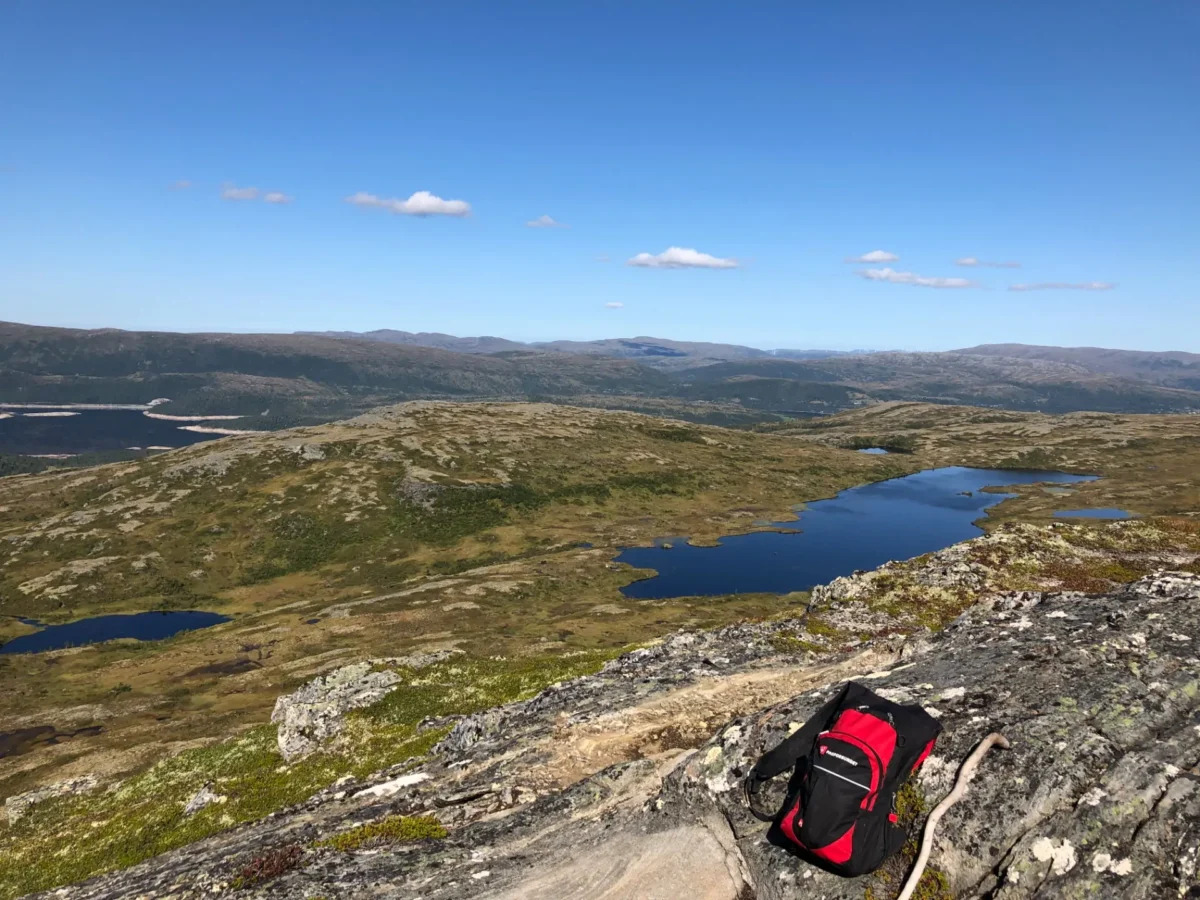 Tursekk på fjellet med utsikt i bakgrunnen, foto