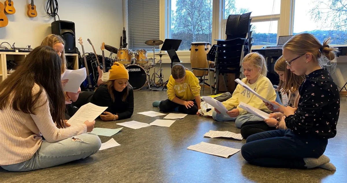 Elever i kulturskolen sitter i en ring og leser manus, foto