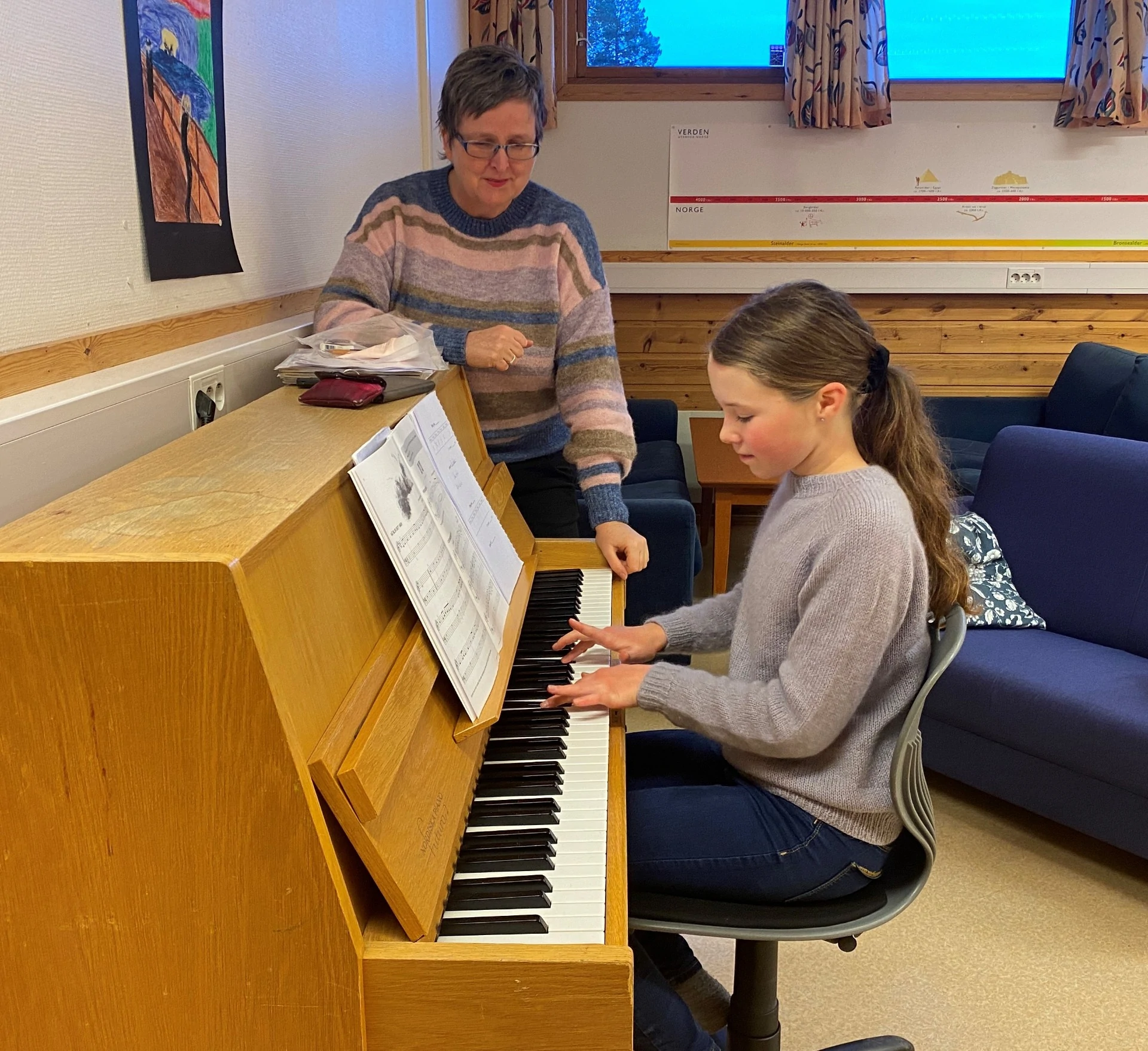 Kulturskolelærer ser på mens elev spiller piano, foto