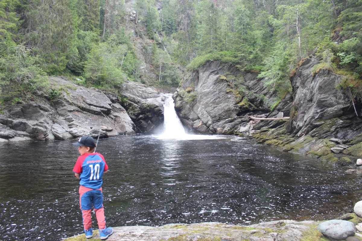 Gutt står foran en elv, foto