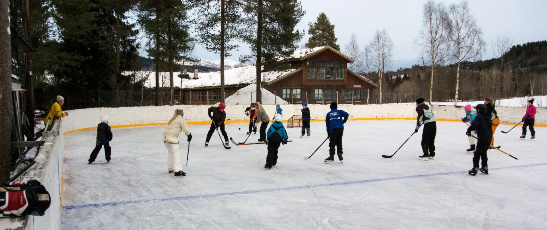 Barn spiller på en utendørs ishockeybane, foto