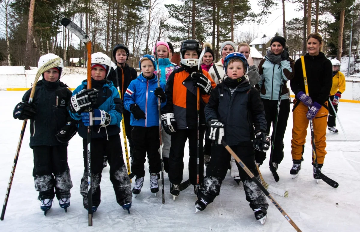 Barn og voksne med ishockeyutstyr, foto