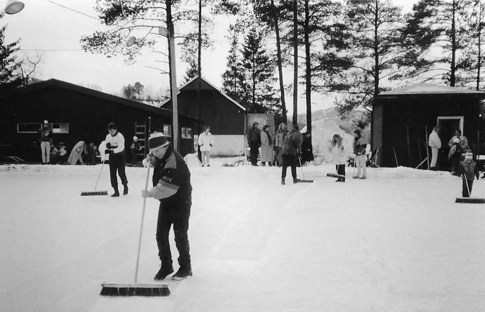 Gammelt bilde av at noen rydder snø av isen, sort-hvitt foto