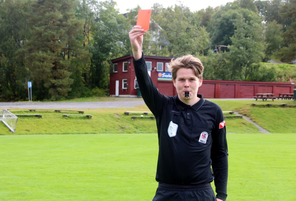 Fotballdommer holder opp rødt kort, foto