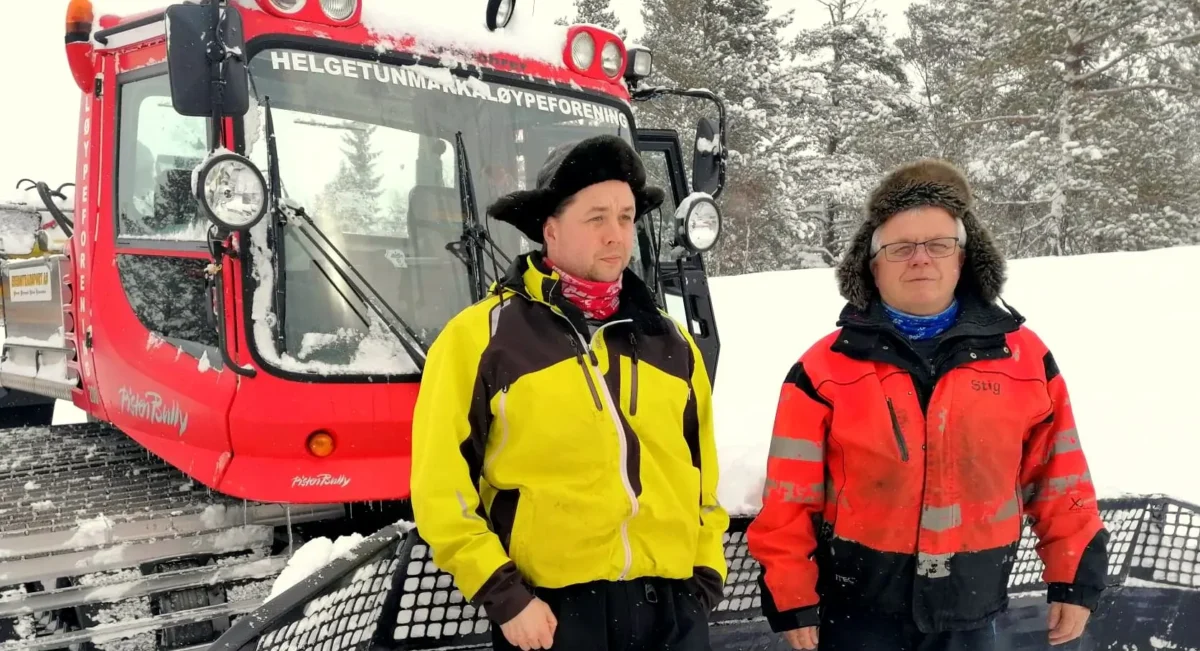 To personer står foran en løypemaskin, vinter og snø, foto