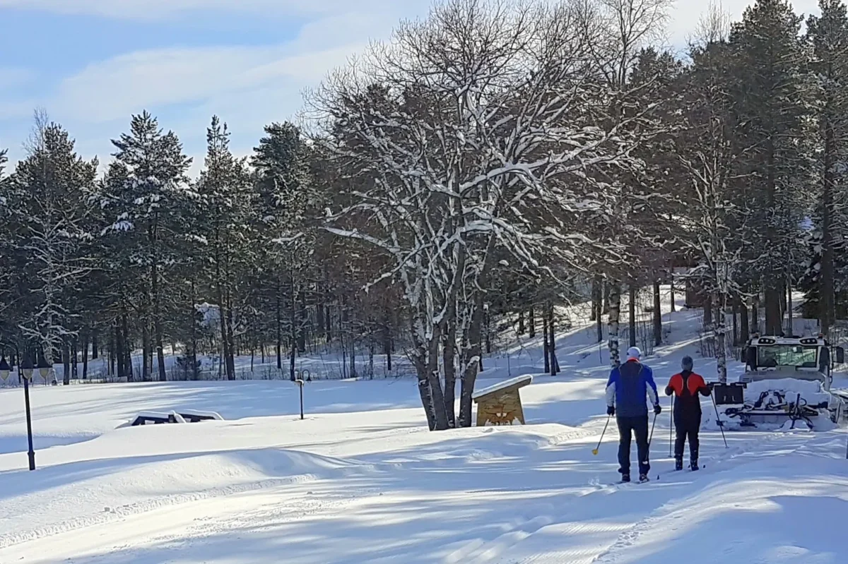 To personer går på ski i skiløype, foto